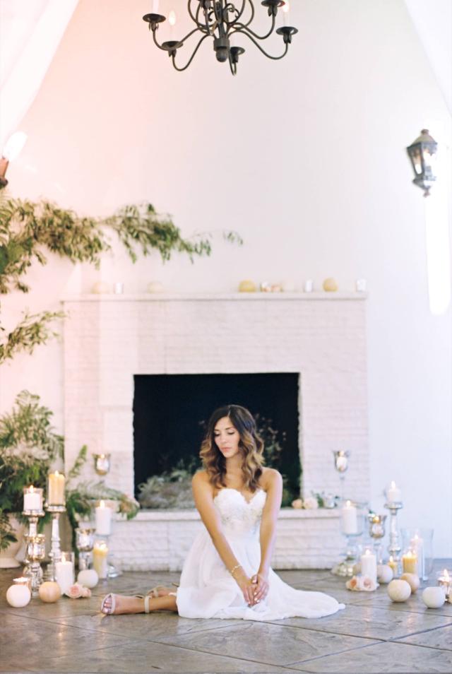 Female Looking Down on Floor in Front of Fireplace Surrounded by Candles at Romantic Riviera