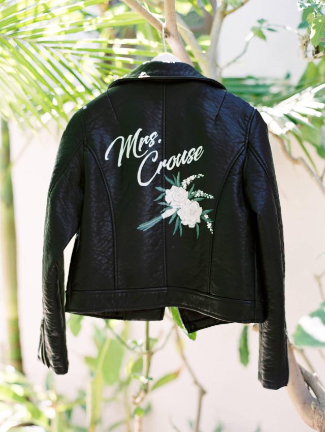 Bride's Leather Jacket Hanging on Outside Archway at Carly & Ben's Wedding