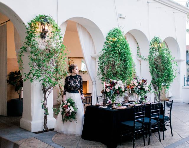 Lady Holding Flowers Along Side of Black Table for Spanish Nights