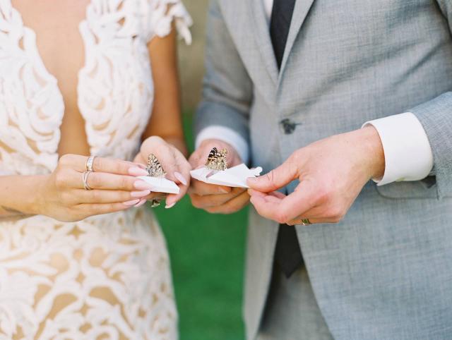 Bride & Groom Holding Butterflies at Carly & Ben's Wedding