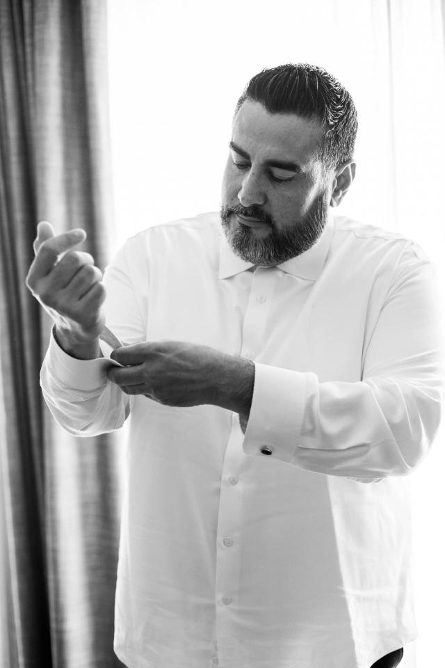 Groom Buttoning Shirt at Evelyn & Gus' Wedding