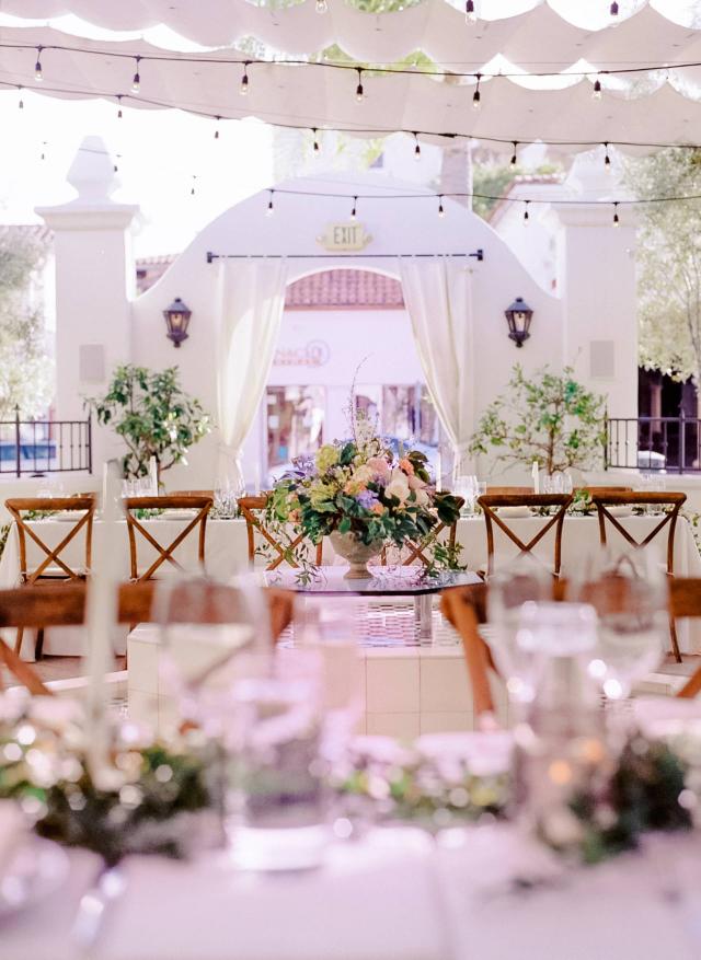Center Flower Arrangement Surrounded by Tables & Chairs at Rhiannon & Joshua's Wedding