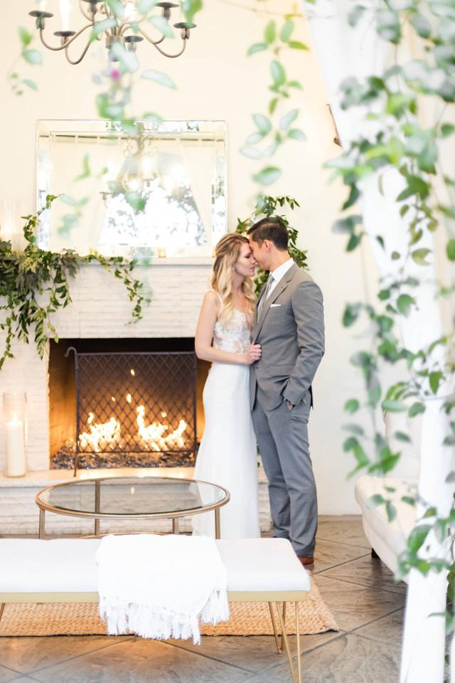 Bride & Groom Looking at Each Other in Front of Fireplace at Angela & Kevin's Wedding