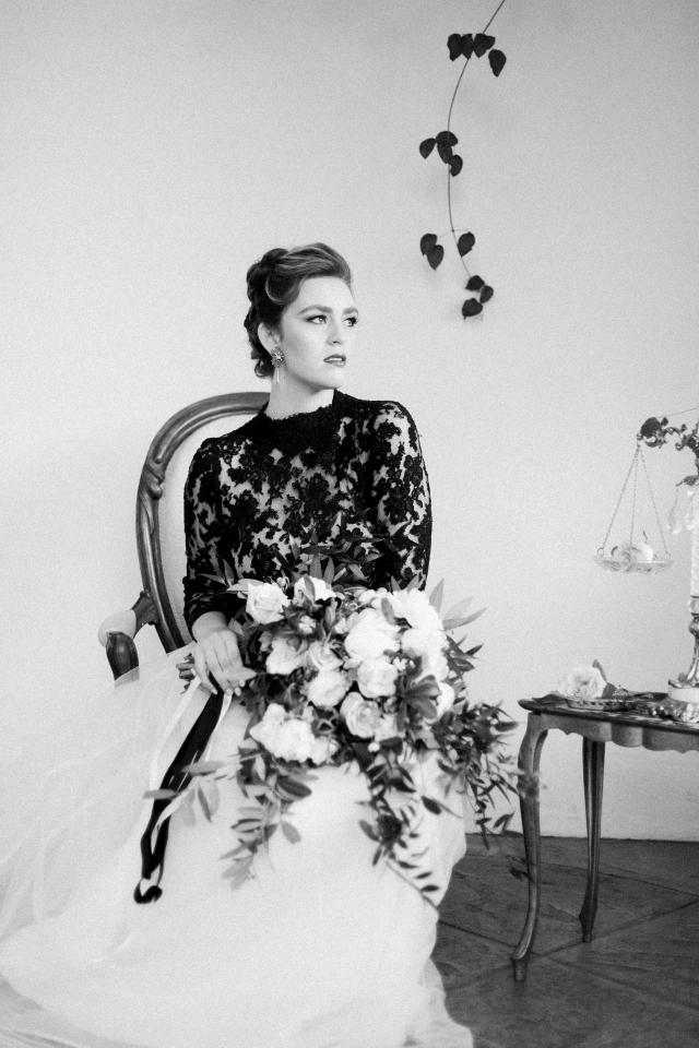 Black & White Closeup of Lady Sitting on Chair, looking Away with Bouquet In Hands for Spanish Nights