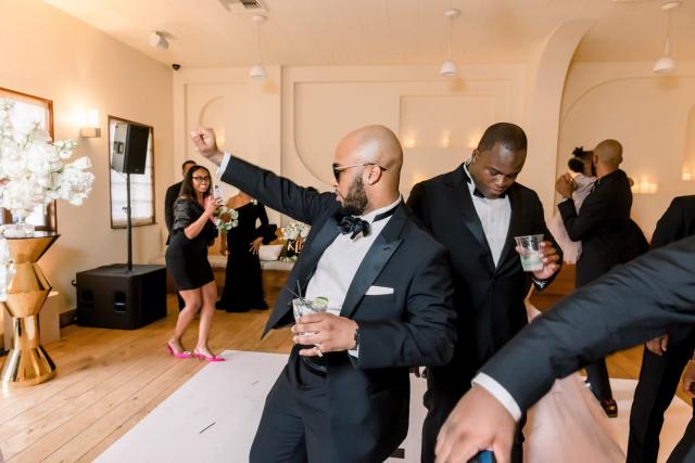 Guys dancing on dance floor with drinks for Daniella & Karl's Wedding