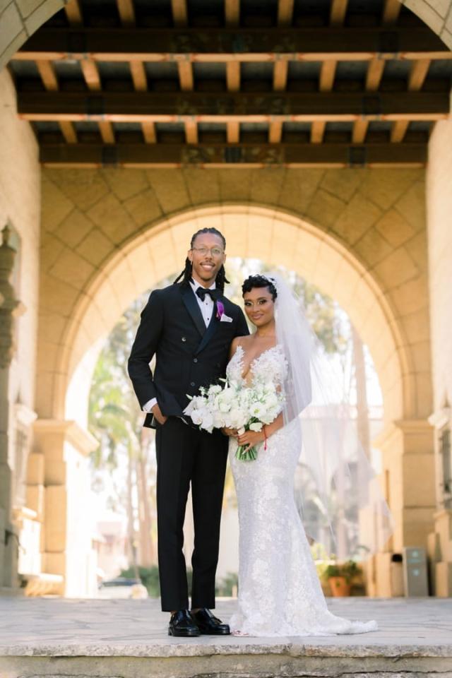 Husband and wife standing under archway for Daniella & Karl's Wedding