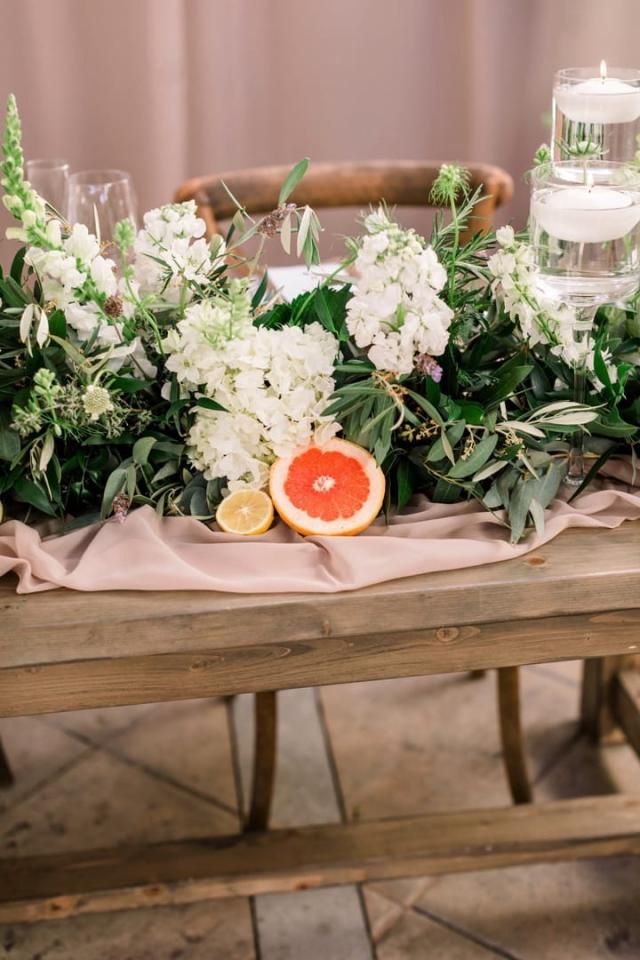 Cut grapefruit and lemon with flowers on wooden table for Danielle & Michael's Wedding