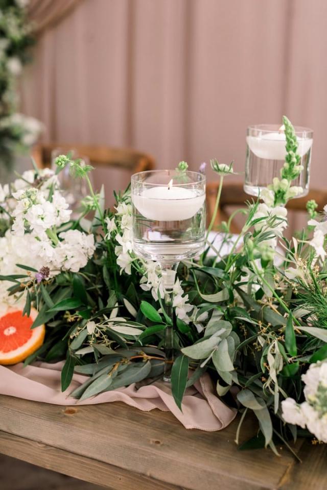 Flower arrangement with candles on wooden table for Danielle & Michael's Wedding