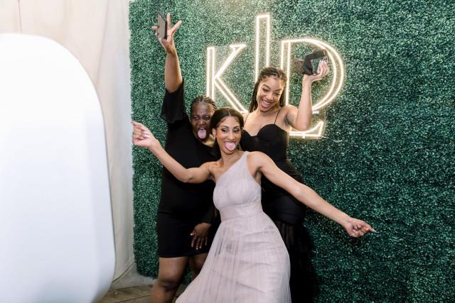 Three girls standing in front of sign with tongues out for Daniella & Karl's Wedding