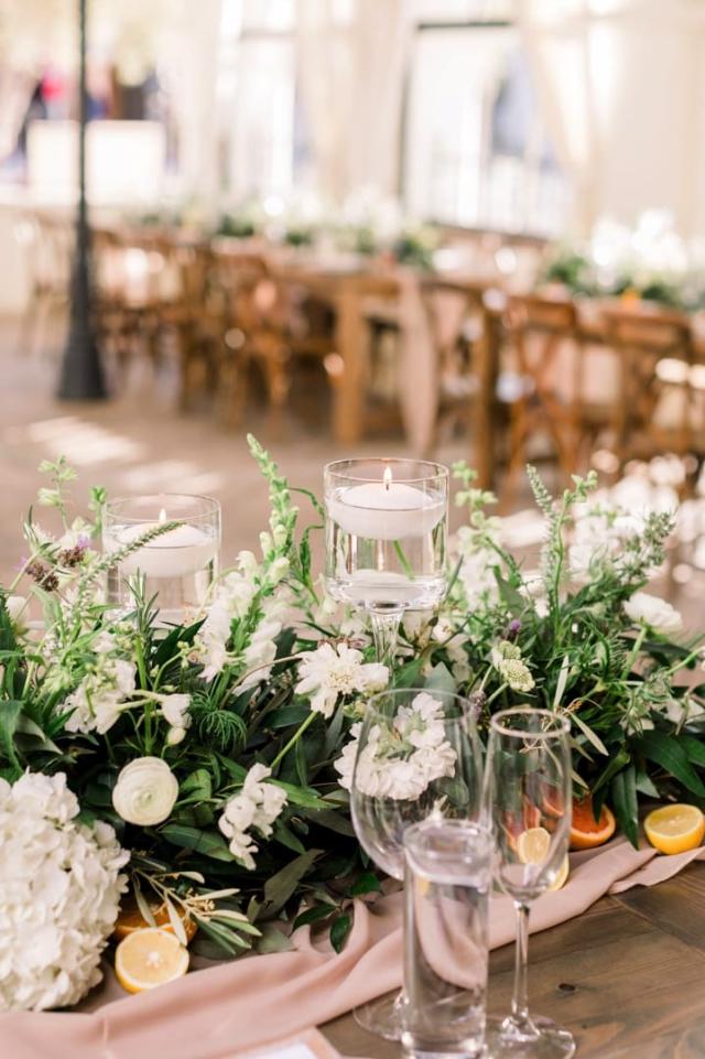 Close up of table flower arrangement with second wooden table in background for Danielle & Michael's Wedding