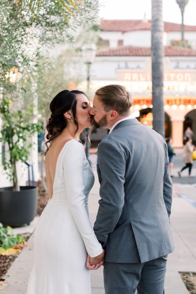 Bride and groom kissing on the street with Arlington Theatre in the background for Danielle & Michael's Wedding