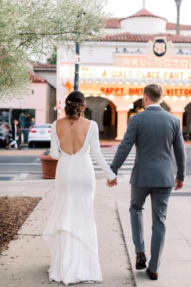 Bride and groom holding hands walking towards the Arlington Theatre for Danielle & Michael's Wedding