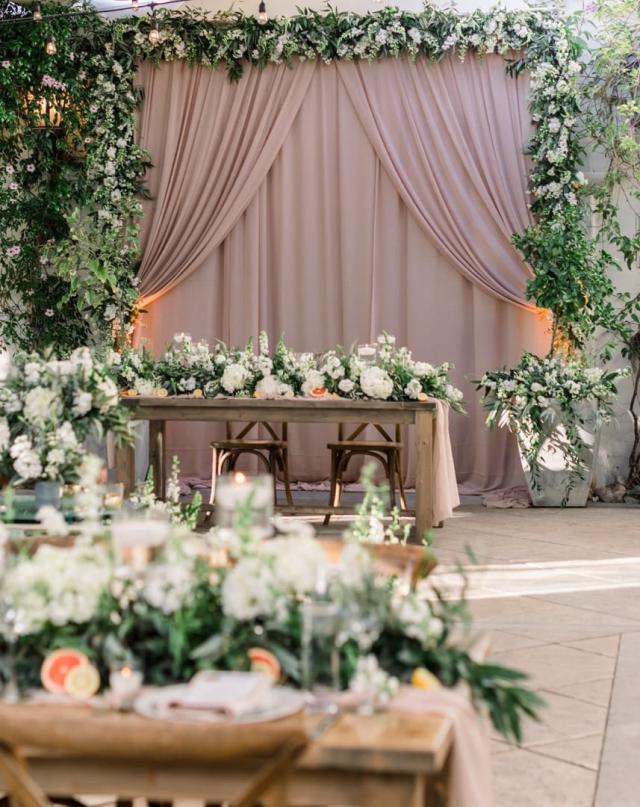 Multiple wooden tables with flower arrangements on top for Danielle & Michael's Wedding