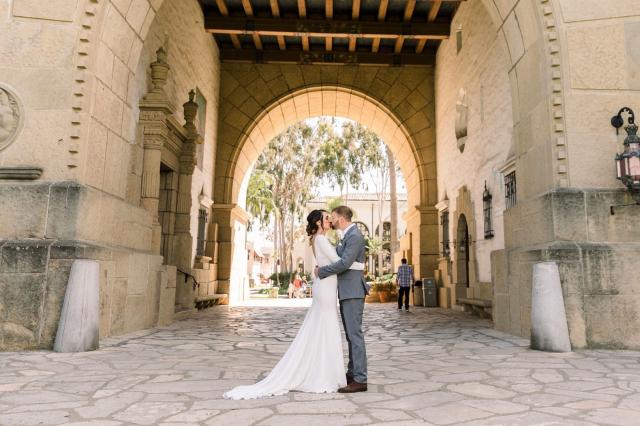 Couple kissing outside standing under archway for Danielle & Michael's Wedding