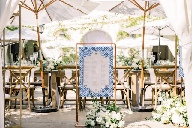 Seating arrangement board with wedding tables in the background for Sara & James’ Wedding