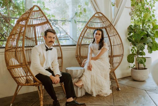 Bride and groom sitting in cane chairs for Paulina & Cam’s Wedding