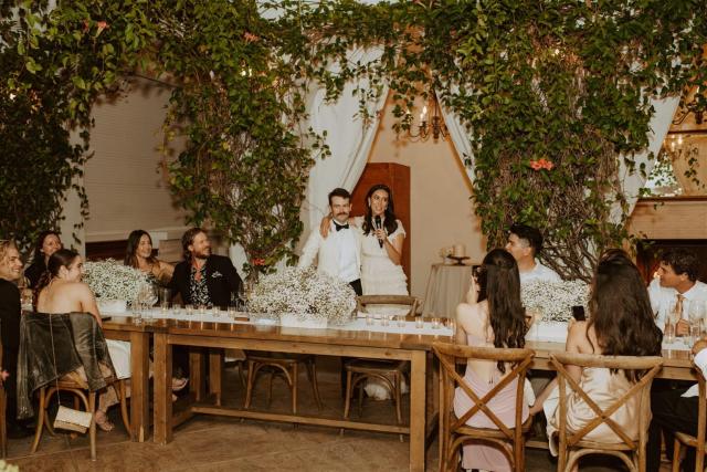 Bride and groom speaking at the wedding table for Paulina & Cam’s Wedding