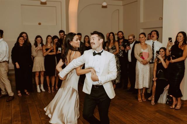 Bride and groom on dance floor surrounded by guests for Paulina & Cam’s Wedding