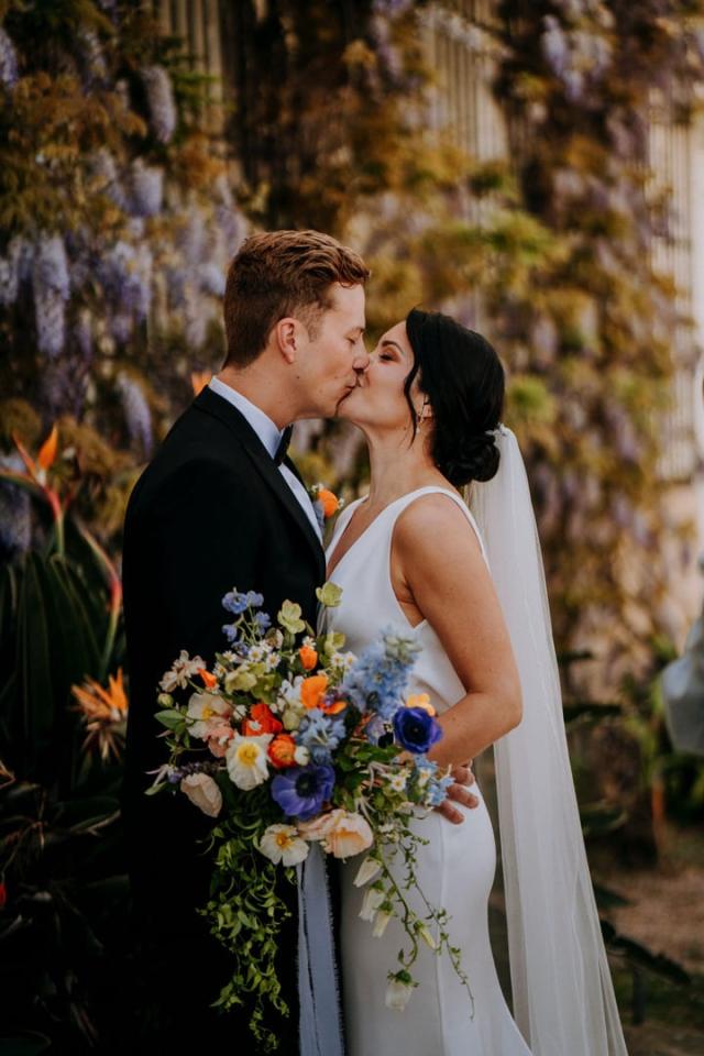 Bride and groom kissing in front of garden for Veronica & Jake’s Wedding