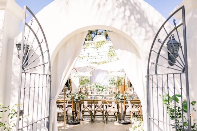 View looking though entrance archway of courtyard wedding tables for Sara & James’ Wedding