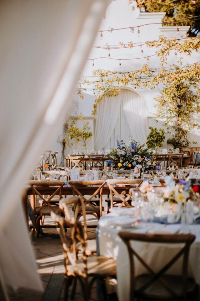 Shot of wedding tables from behind a curtain for Veronica & Jake’s Wedding