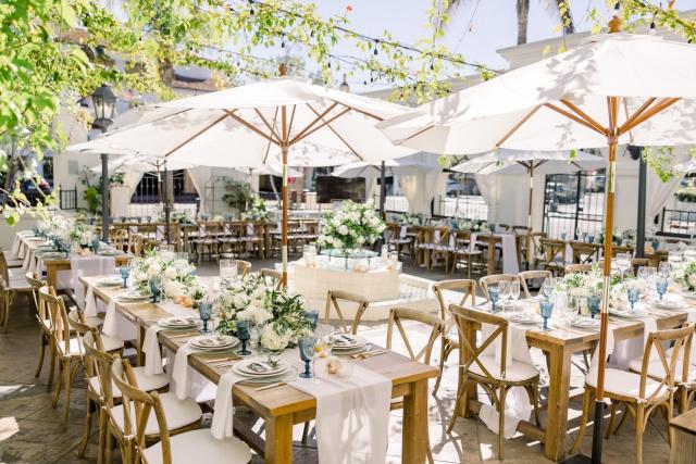 Side angle of courtyard wedding tables with central flower arrangement for Sara & James’ Wedding