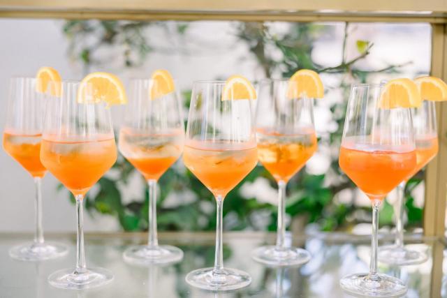 Close view of wine glasses filled with orange liquid for Sara & James’ Wedding