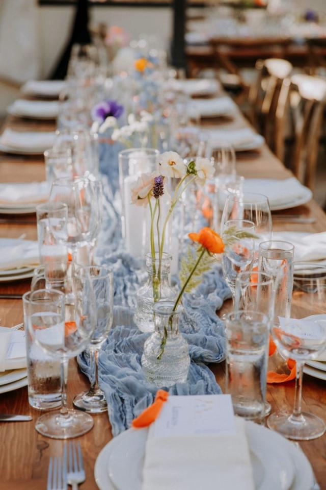 Long shot of wedding table with place sets, flowers, and candles for Veronica & Jake’s Wedding