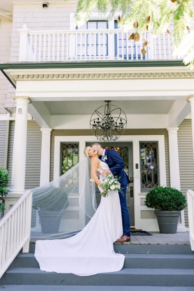 Bride leaning back as groom kisses neck on steps for Sara & James’s Wedding
