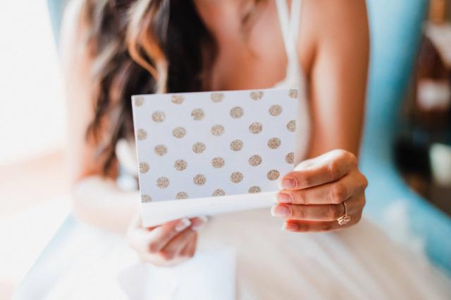 A person holding a card for Jennifer & Lars' Wedding