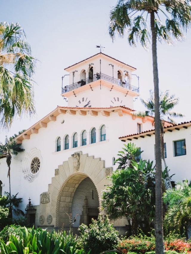 A white building with a clock tower and palm trees  for Jennifer & Lars' Wedding
