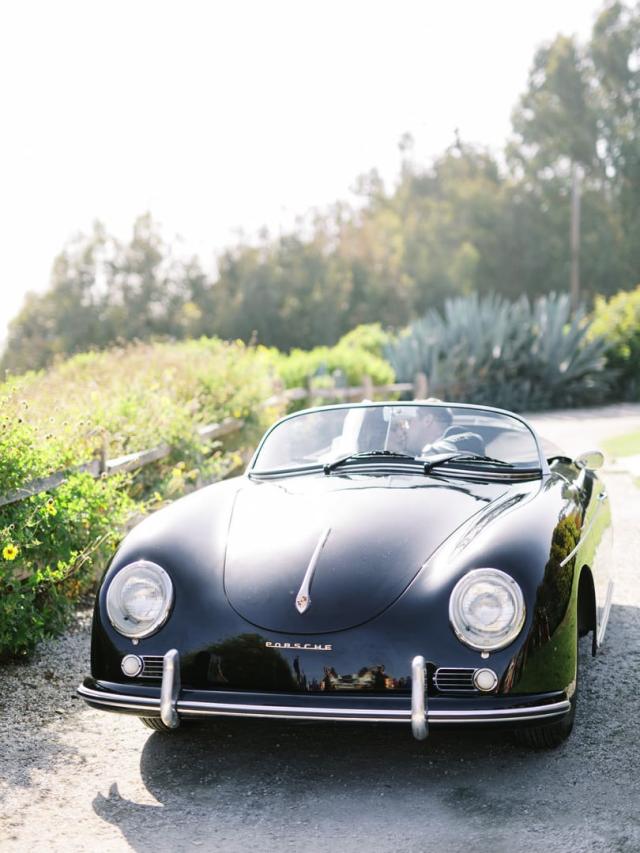 Shot of classic black open top Porsche with bride and groom inside for Jammie & Duncan's Wedding