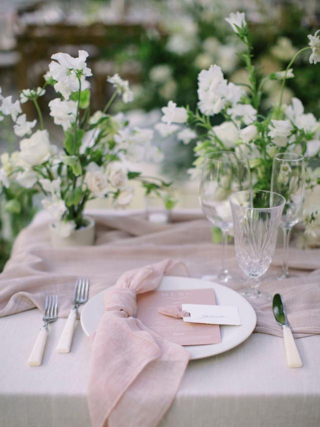 View of a single placemat, flowers, pink napkin and bone handled cutlery for Jammie & Duncan's Wedding