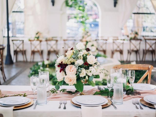 View of 2 place sets with white plates, flowers and glasses for Jennifer & Lars' Wedding