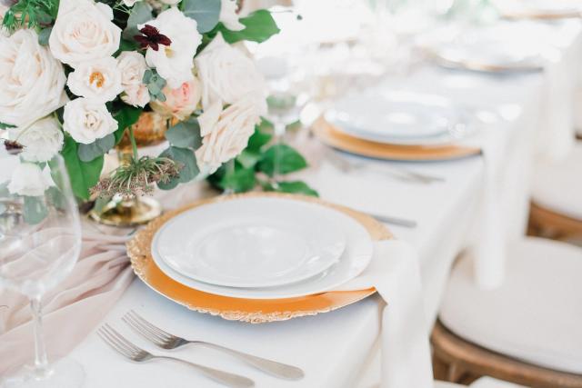 Multiple place sets of white plates, flowers and pink table cloth for Jennifer & Lars' Wedding