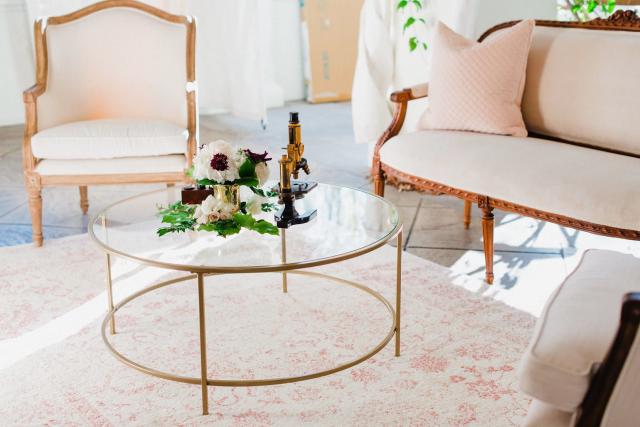 Glass table with flowers on it surrounded by couch and chair for Jennifer & Lars' Wedding