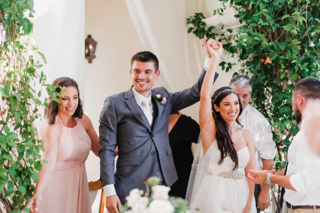 Groom holding bride's arm up smiling for Jennifer & Lars' Wedding