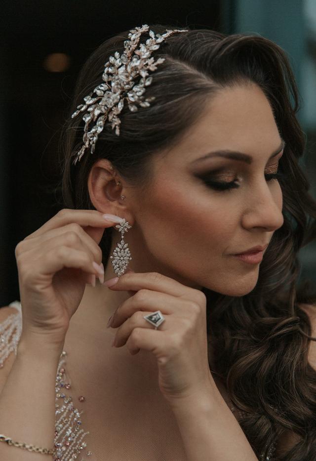 Close-up of the bride putting her earring in for Ivanka & Victoria's wedding