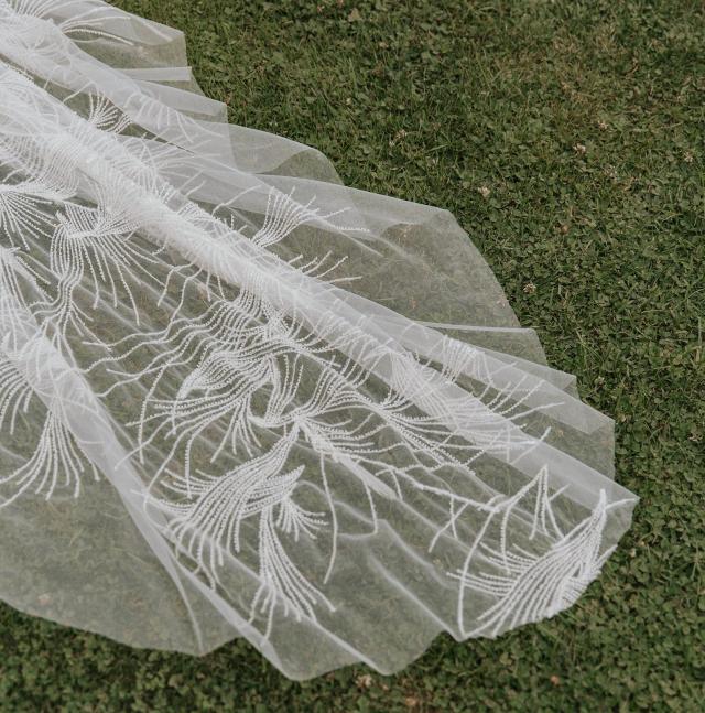 End of the wedding dress, showing the lace pattern on the grass for Ivanka & Victoria's wedding