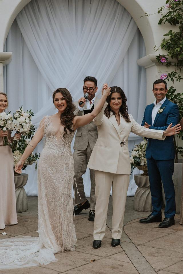 Bride and groom with their hands up, celebrating their marriage for Ivanka & Victoria's Wedding