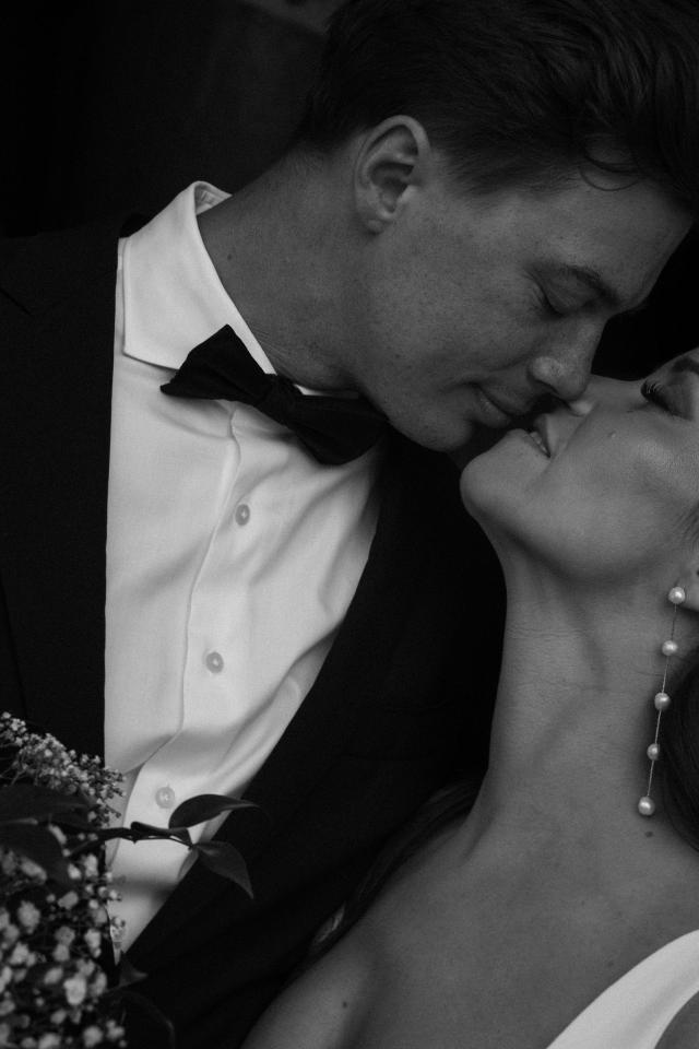 Black and white photo of Groom kissing Bride for Lauren & Russell's Wedding