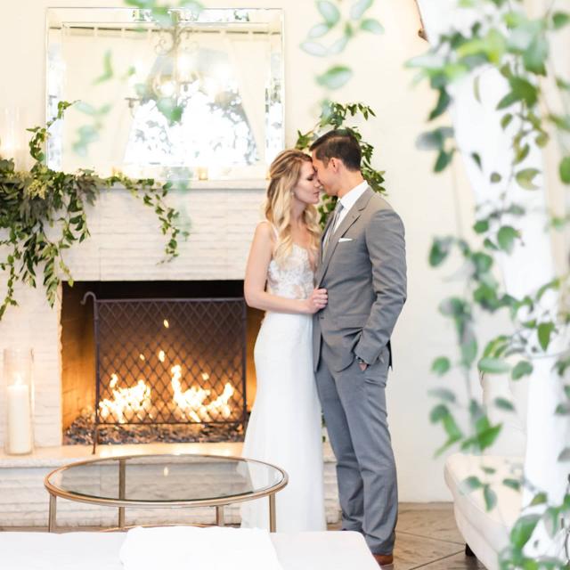 Bride & Groom Looking at Each Other in Front of Fireplace at Angela & Kevin's Wedding