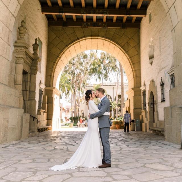 Couple kissing outside standing under archway for Danielle & Michael's Wedding